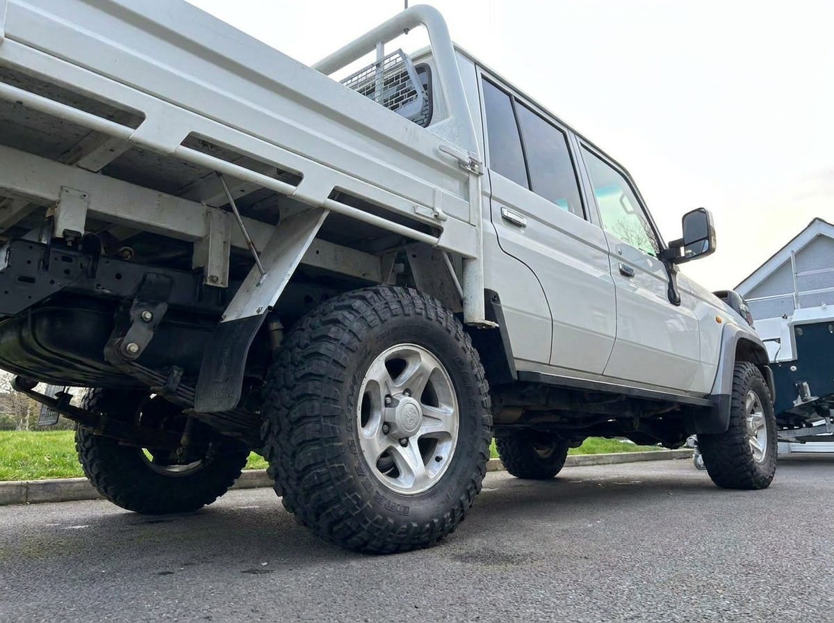 Low angle shot of a white Land Cruiser pickup with tinted side windows