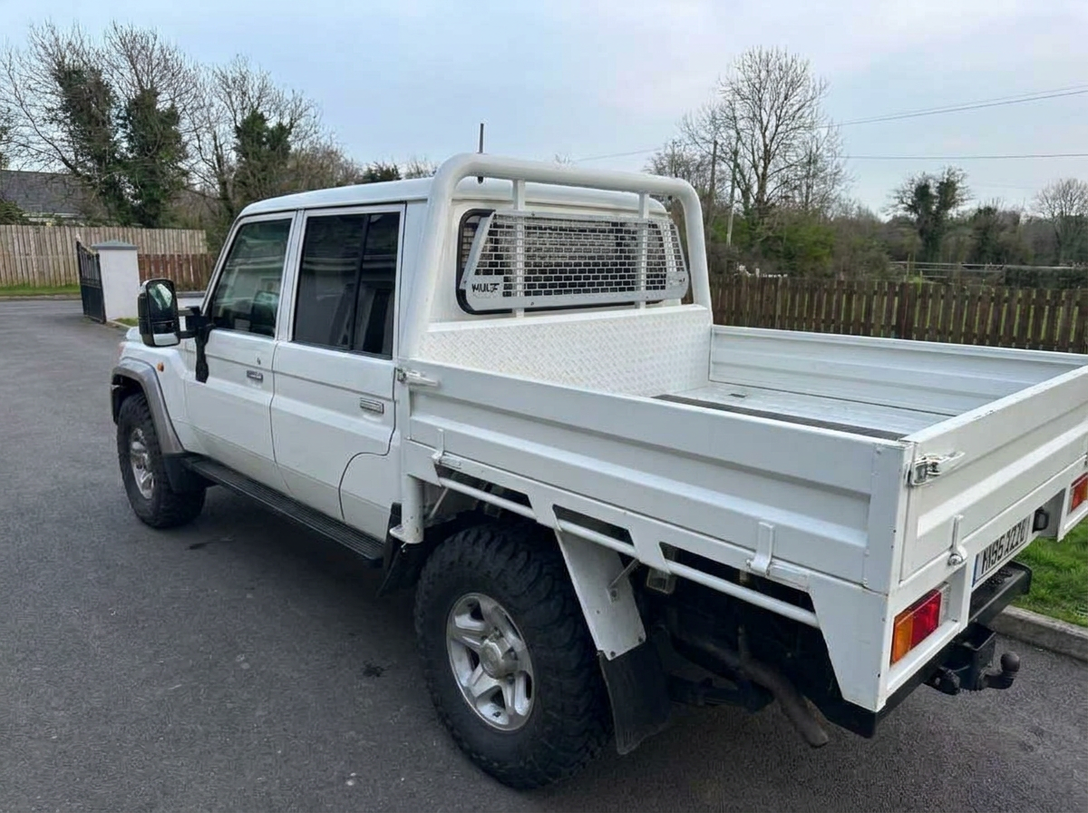 Rear three-quarter view of a tinted white Land Cruiser pickup