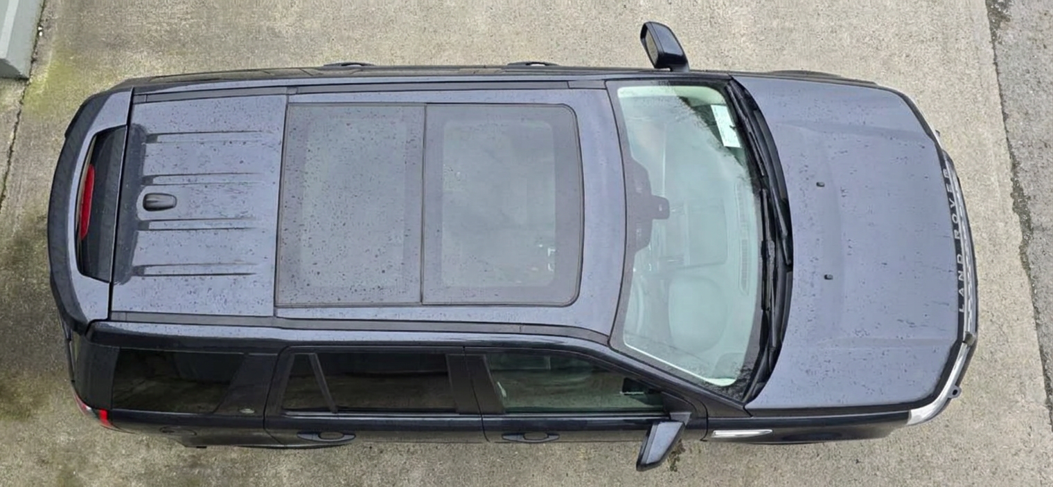 Top-down view of a dark blue Land Rover Freelander 2 showing the tinted panoramic roof glass