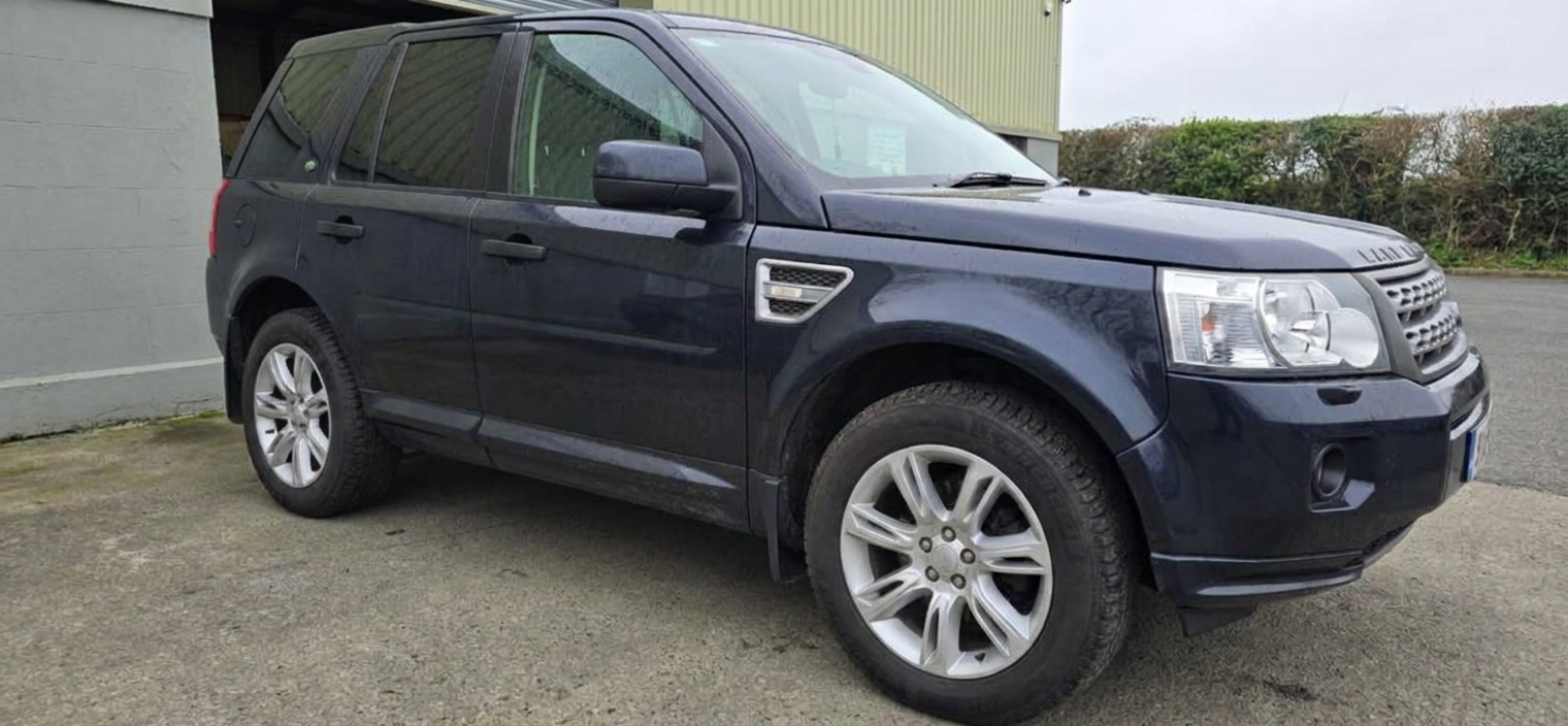 Front-right three-quarter view of a tinted dark blue Land Rover Freelander 2