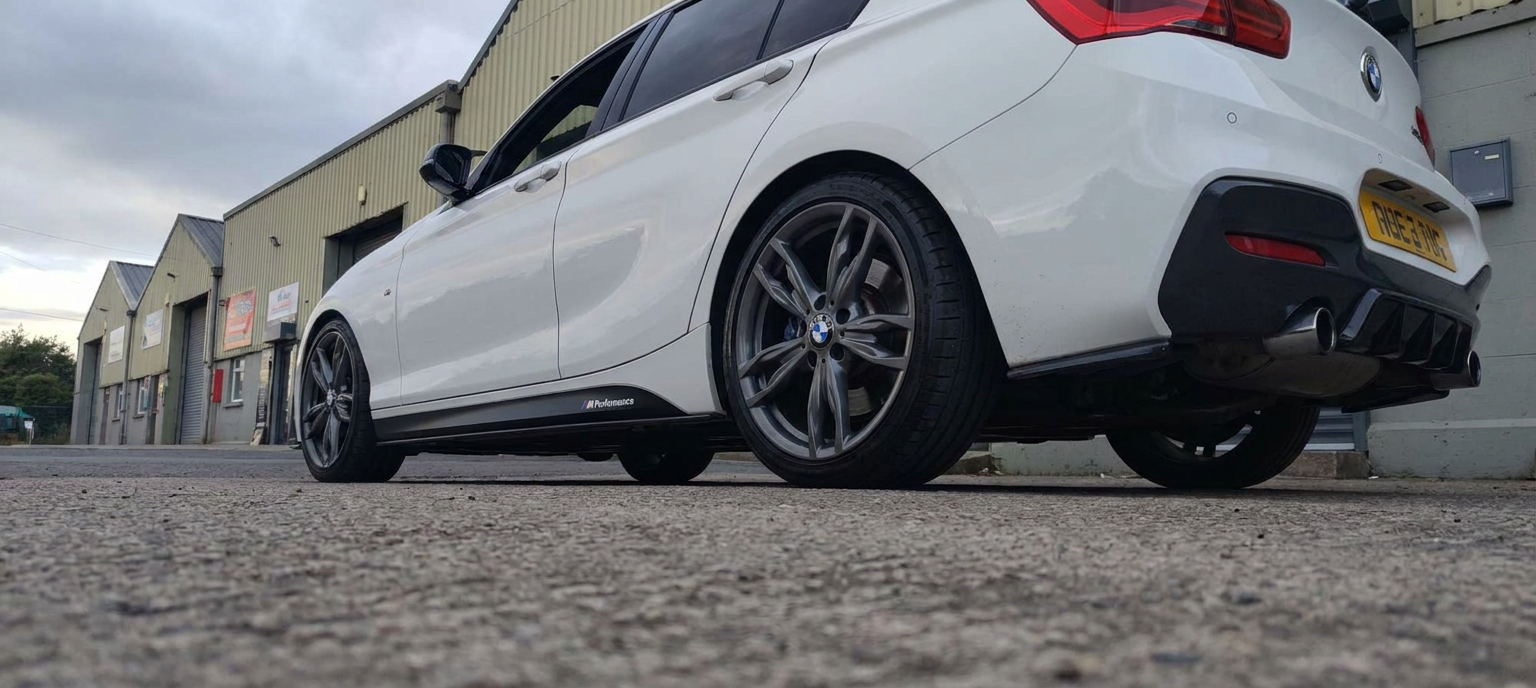 Low angle rear view of a tinted white BMW hatchback
