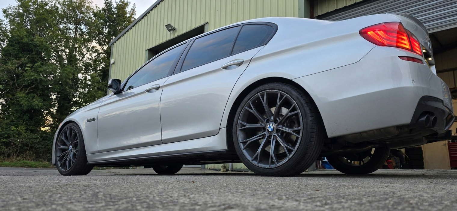 Low angle rear three-quarter of a tinted silver BMW